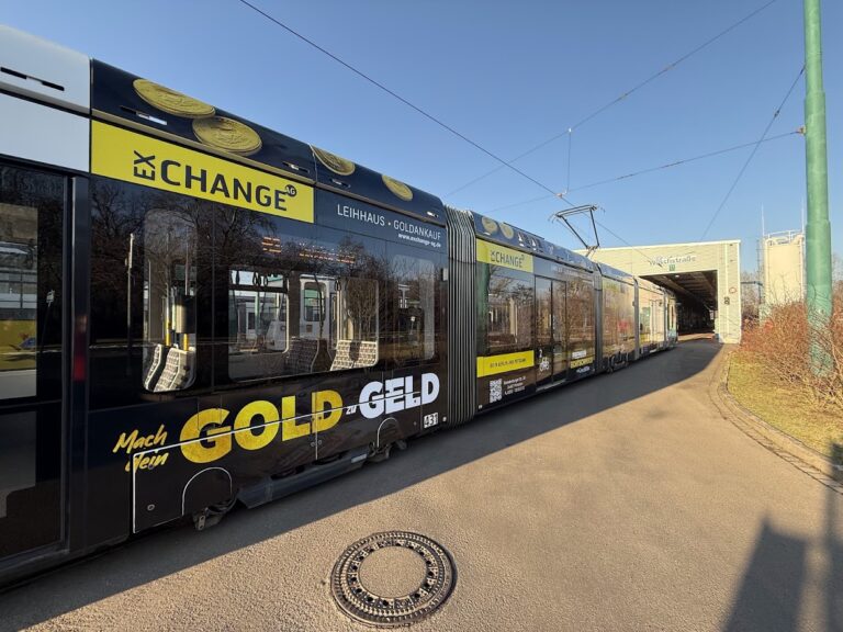 Schwarz und goldgelb beschriftete Straßenbahn mit GOLDzuGELD-Werbung